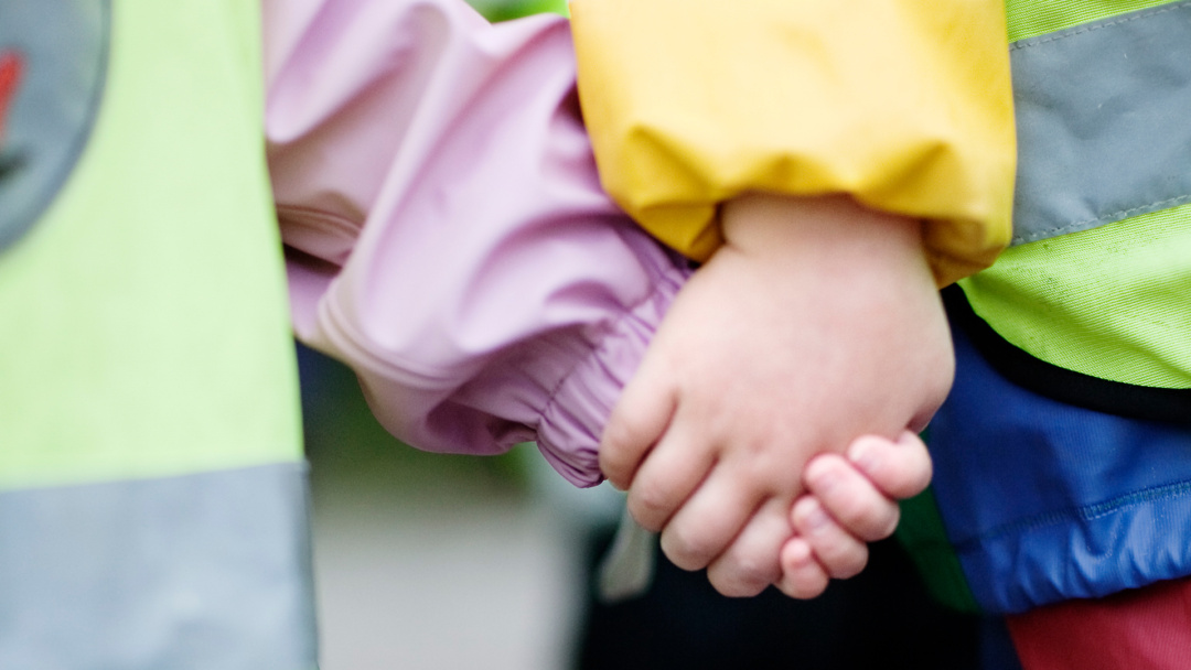Två föreskolebarn som håller varandra i händerna. (foto: Anna Olsson)