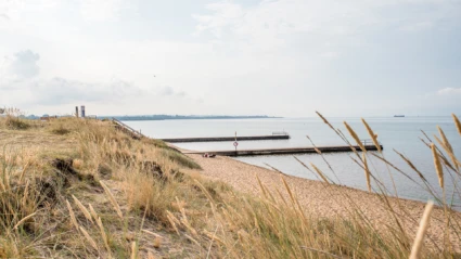 Två bryggor och sandstrand vid Knähakens badplats