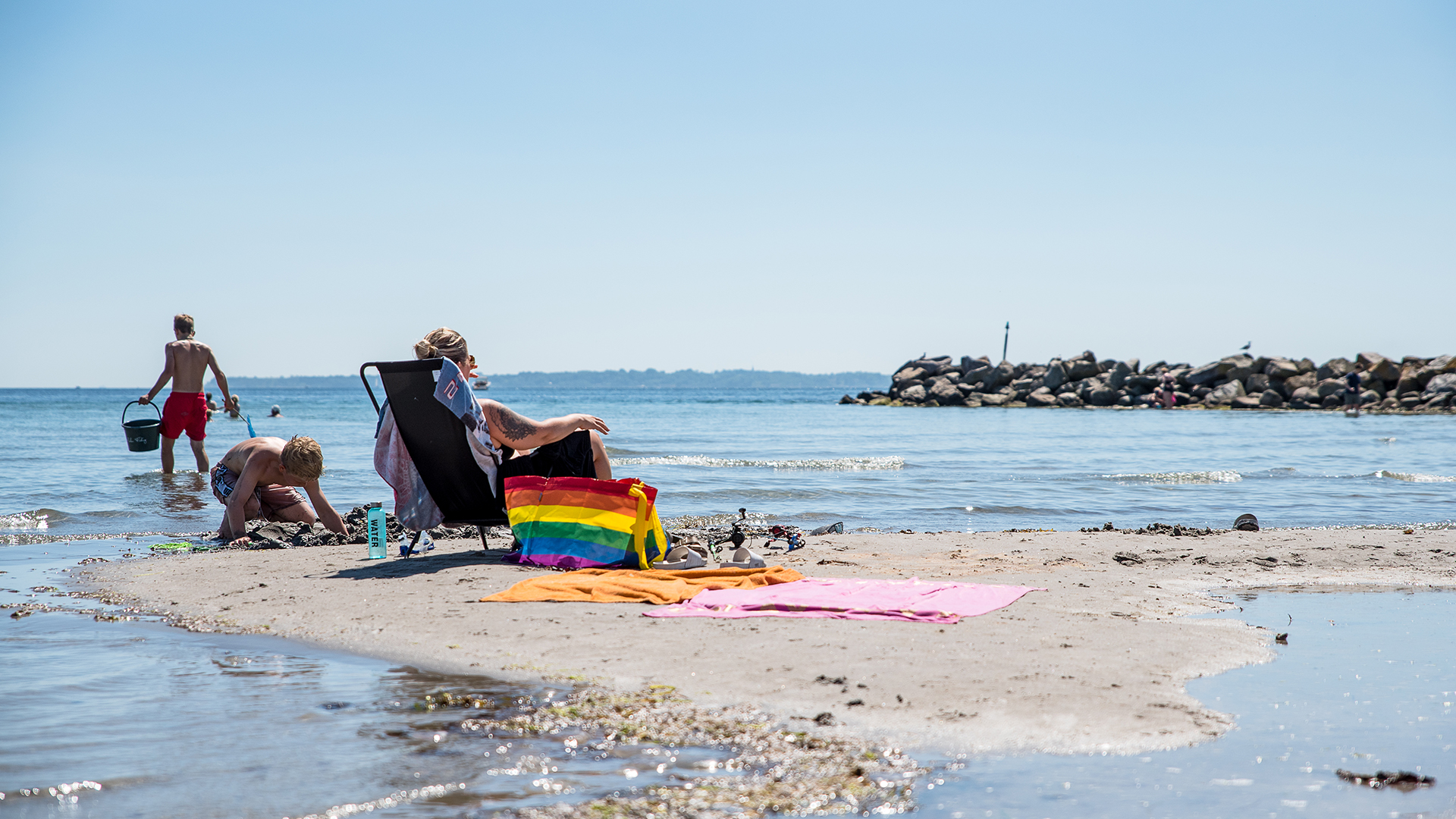 Person i solstol på stranden vid Örby ängar norra