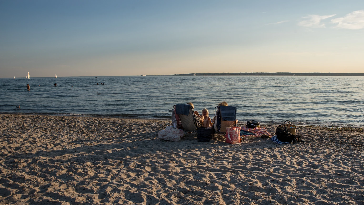 Personer på stranden vid badplatsen vid Pålsjö i skymningen