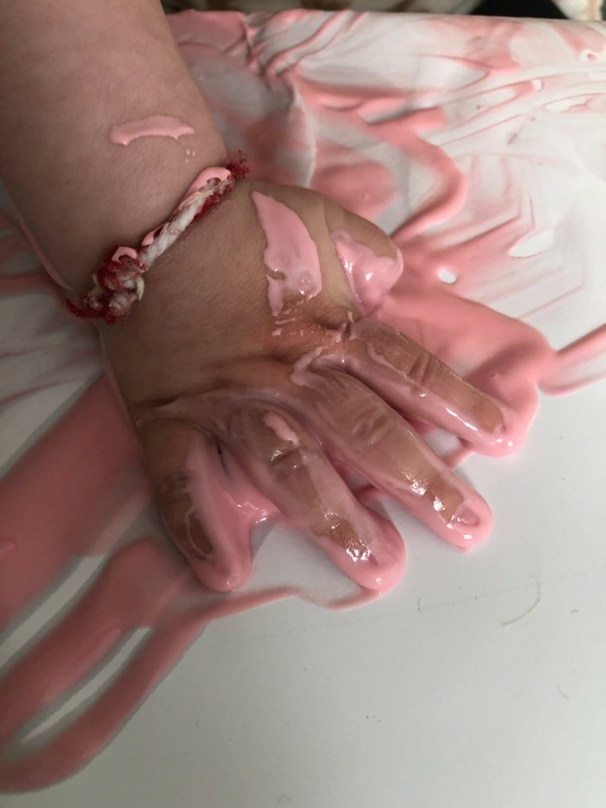 Barnhand med rosa färg