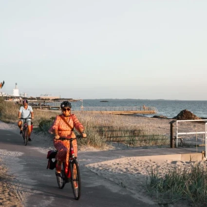Cyklist cyklar längs en strand.