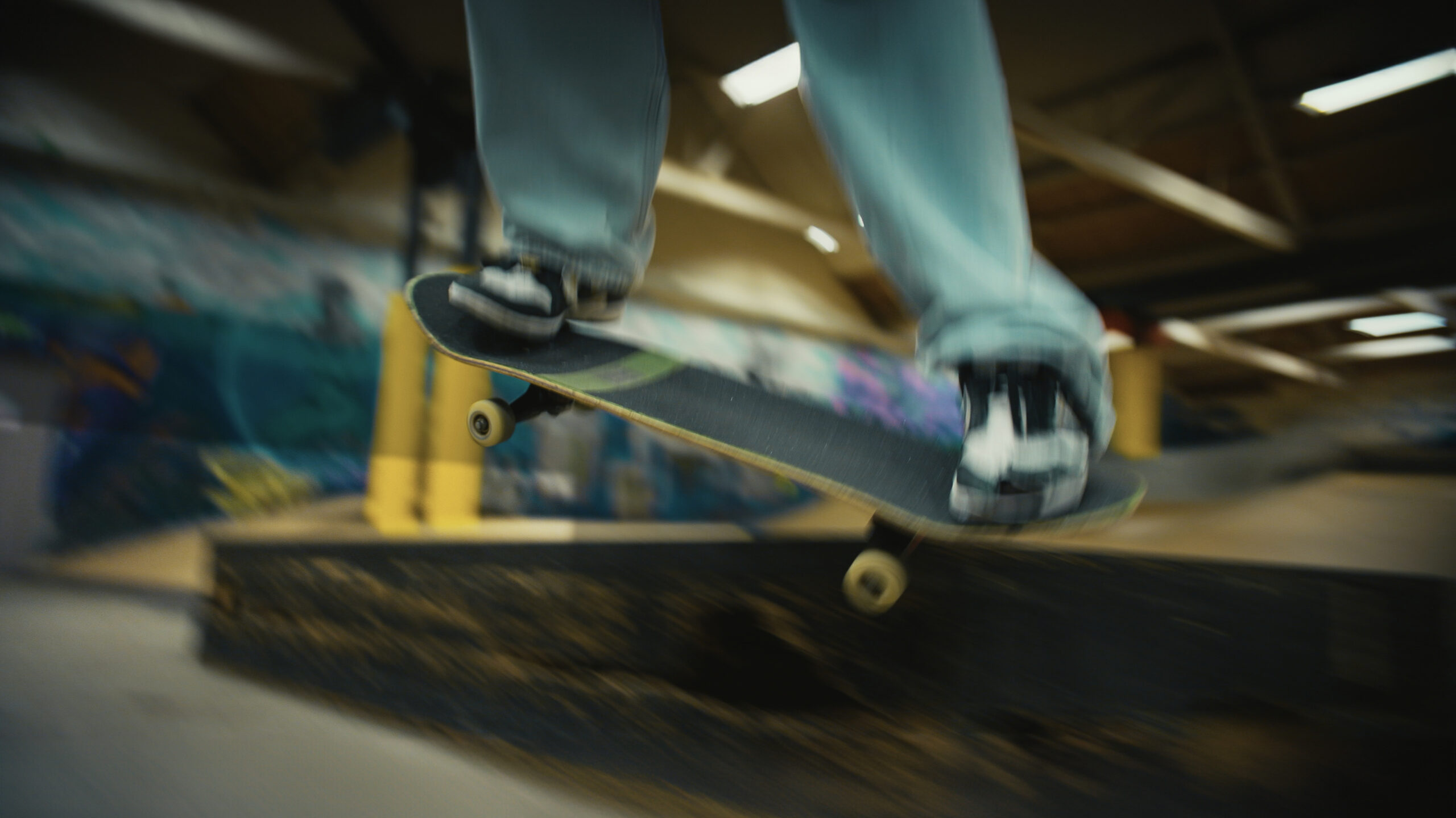 Skateboardåkare gör ett trick i skatehallen på Jutan.