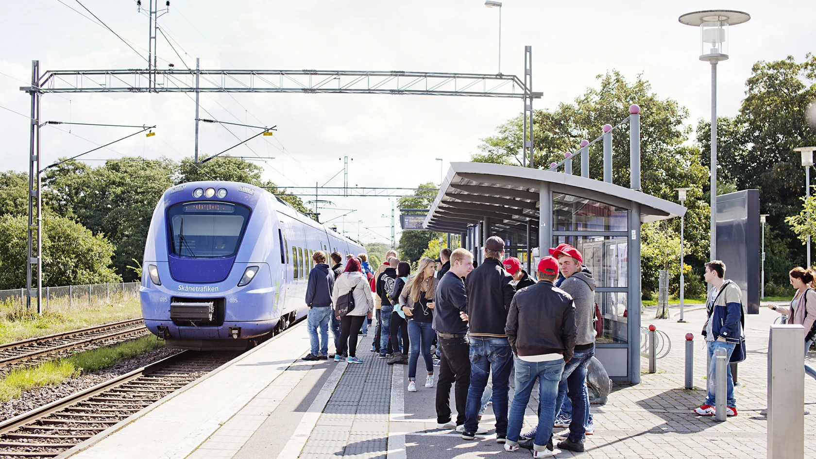 Människor som väntar på ett tåg i Vallåkra.