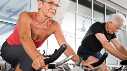 Kvinna och man på motionscykel. (foto: Colourbox)