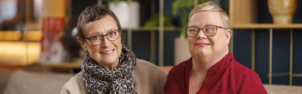 Lena och Eva sitter bredvid varandra i en soffa