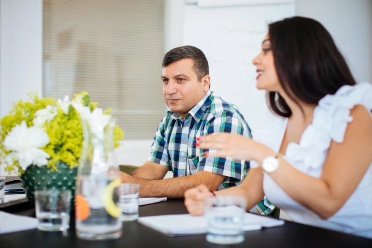 En man och en kvinna som sitter vid ett bord och studerar.