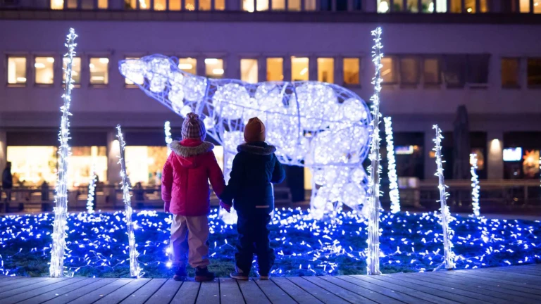 Två barn tittar på en av Helsingtborgs vinterljusinstallationer, isbjörnen på Rådhustorget i Helsingborg.