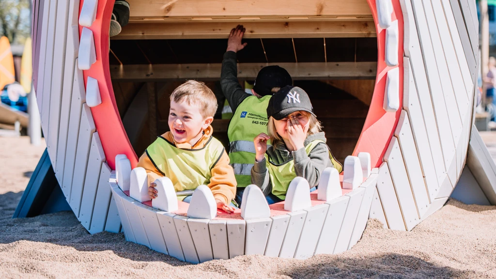 Tre barn i hajgapet på lekplatsen Surflekan