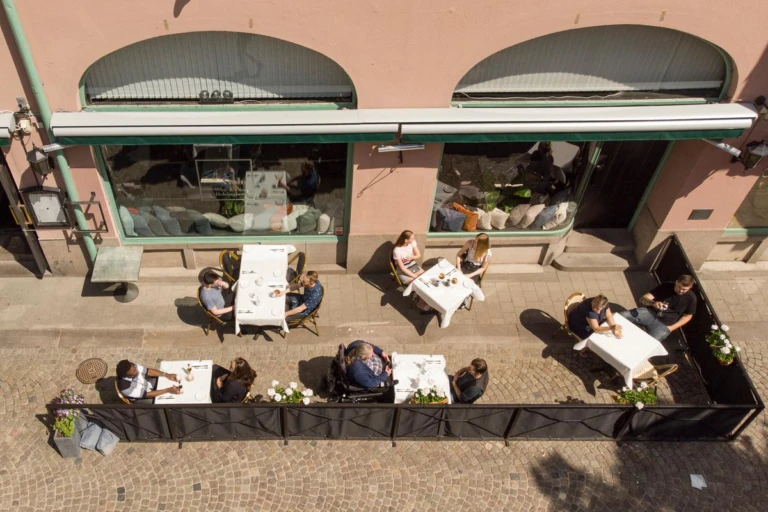 Personer sitter vid bord på en uteservering