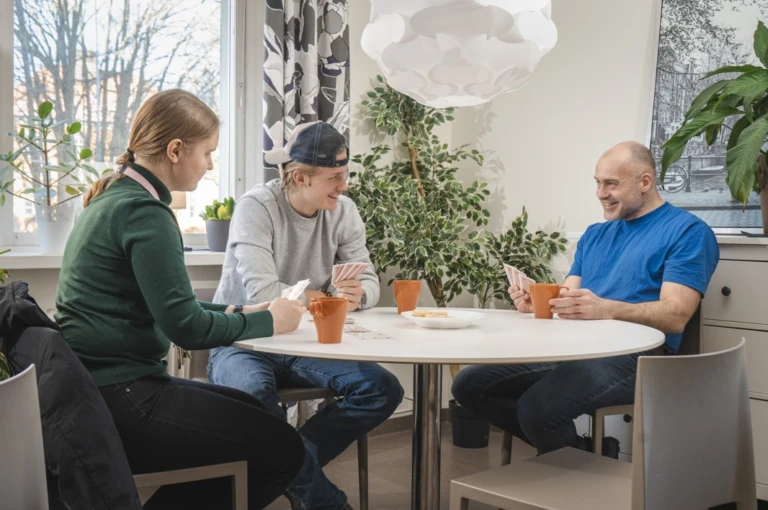 Tre personer runt ett bord