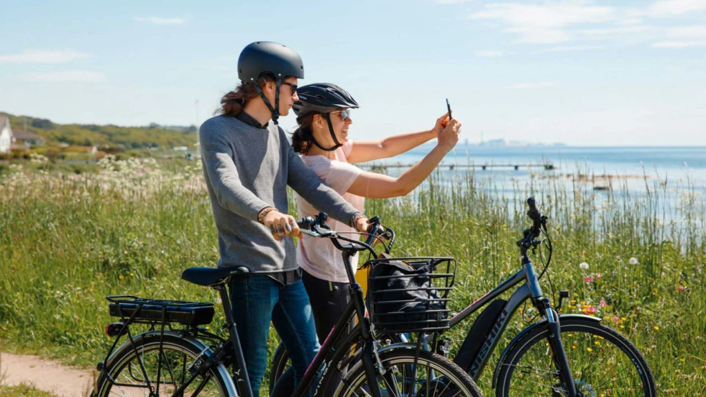 Två personer på cykelutflykt vid Öresund. De tar en selfie.