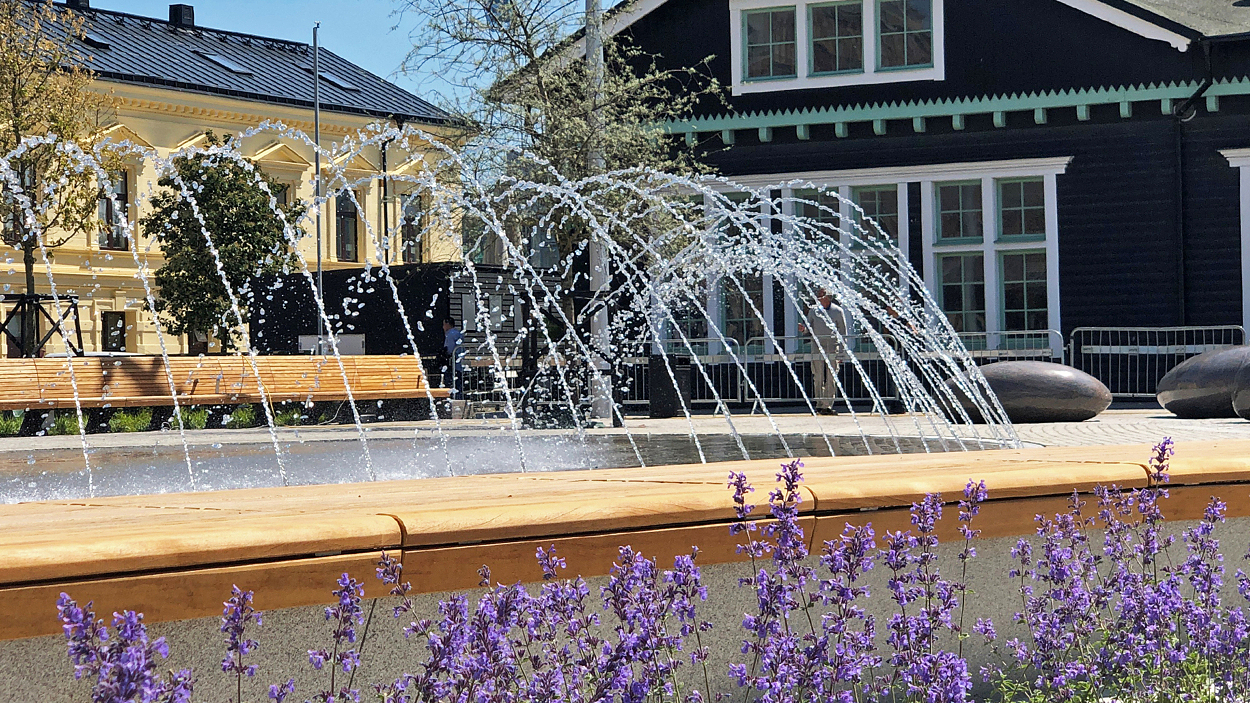 Ångfärjeparken i Helsingborg. Närbild av vattenspelet/fontänen med blommande rabatt i förgrunden.