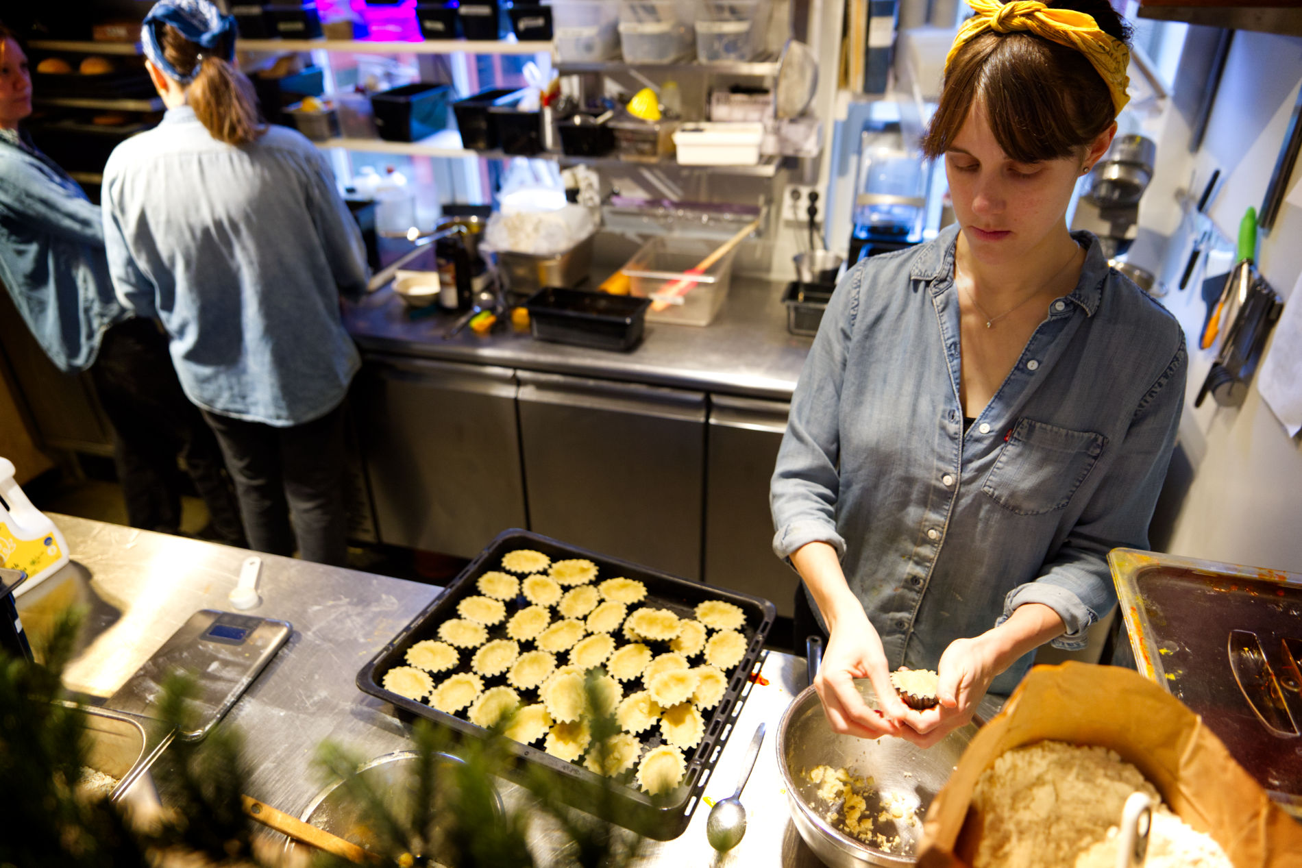 Hanna Bergström bakar mandelmusslor och lägger på en plåt i ett kafékök