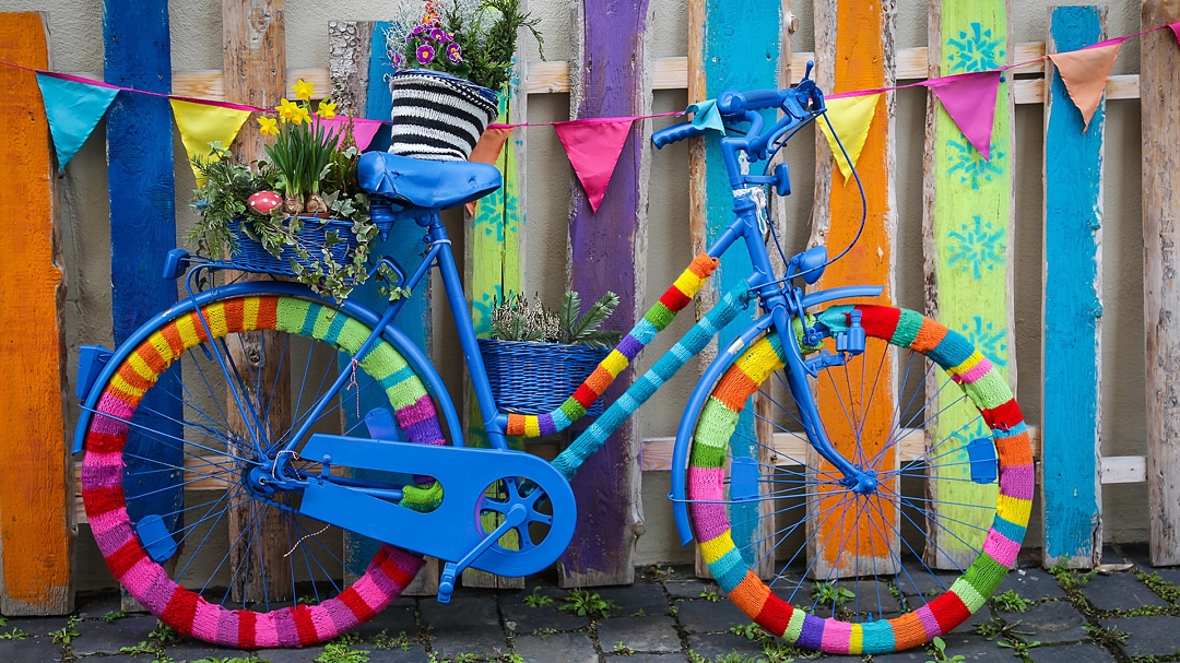 Färgglad cykel vid lika färgglatt plank.