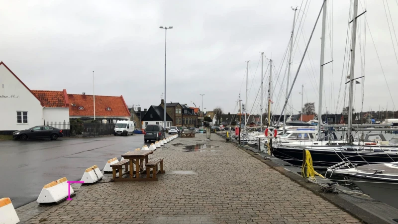 En av åtgärderna kan vara att anlägga en cirka 30 centimeter hög mur längs kajen. Den rosa linjen i bilden visar på ett ungefär hur högt upp 30 centimeter sträcker sig. Vi är måna om att muren ska smälta in i platsens miljö.