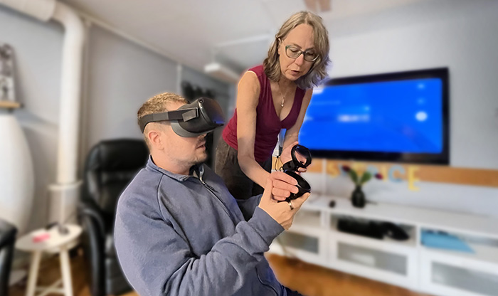 En kvinna instruerar en man i hur man använder VR-utrustning.