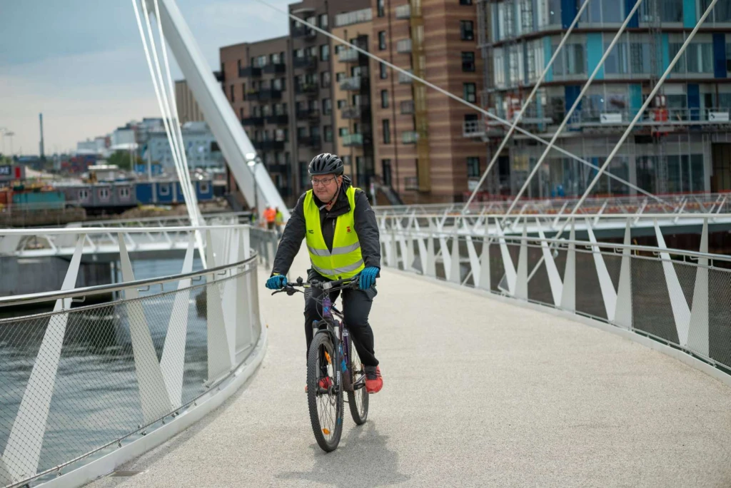 Cyklist på väg upp för Varvsbron i Helsingborg med Oceanhamnen i bakgrunden.