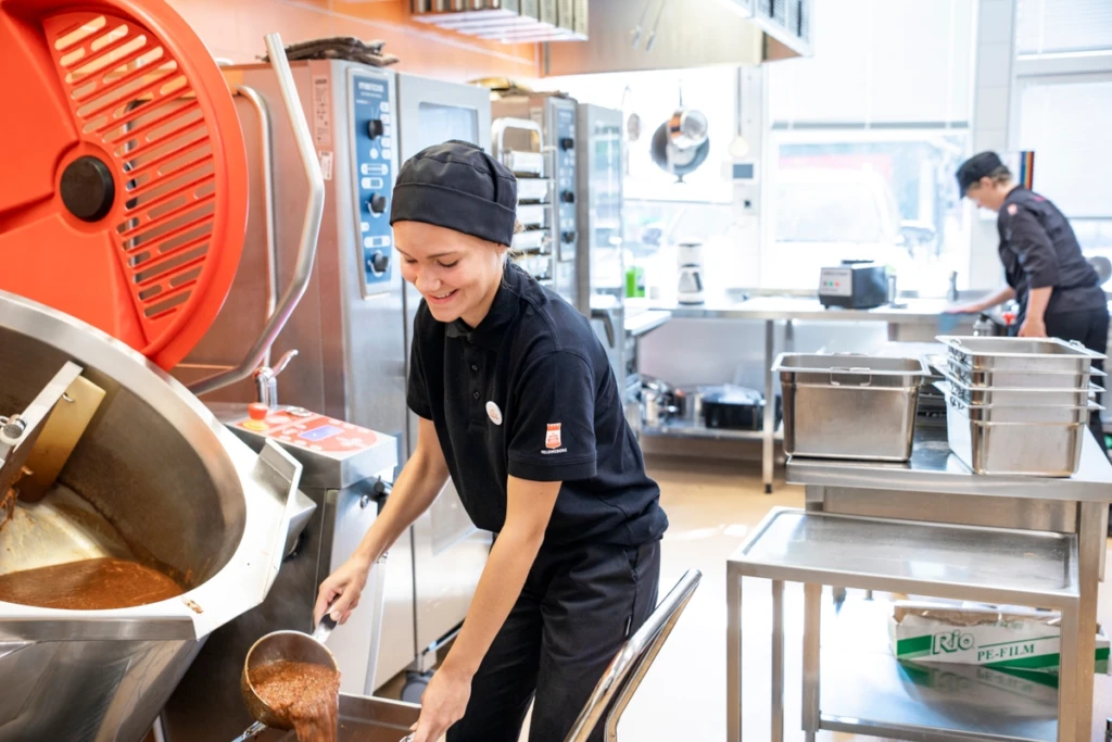 Två sommarvikarier lagar mat i stora tråg och grytor på en skola i Helsingborg.