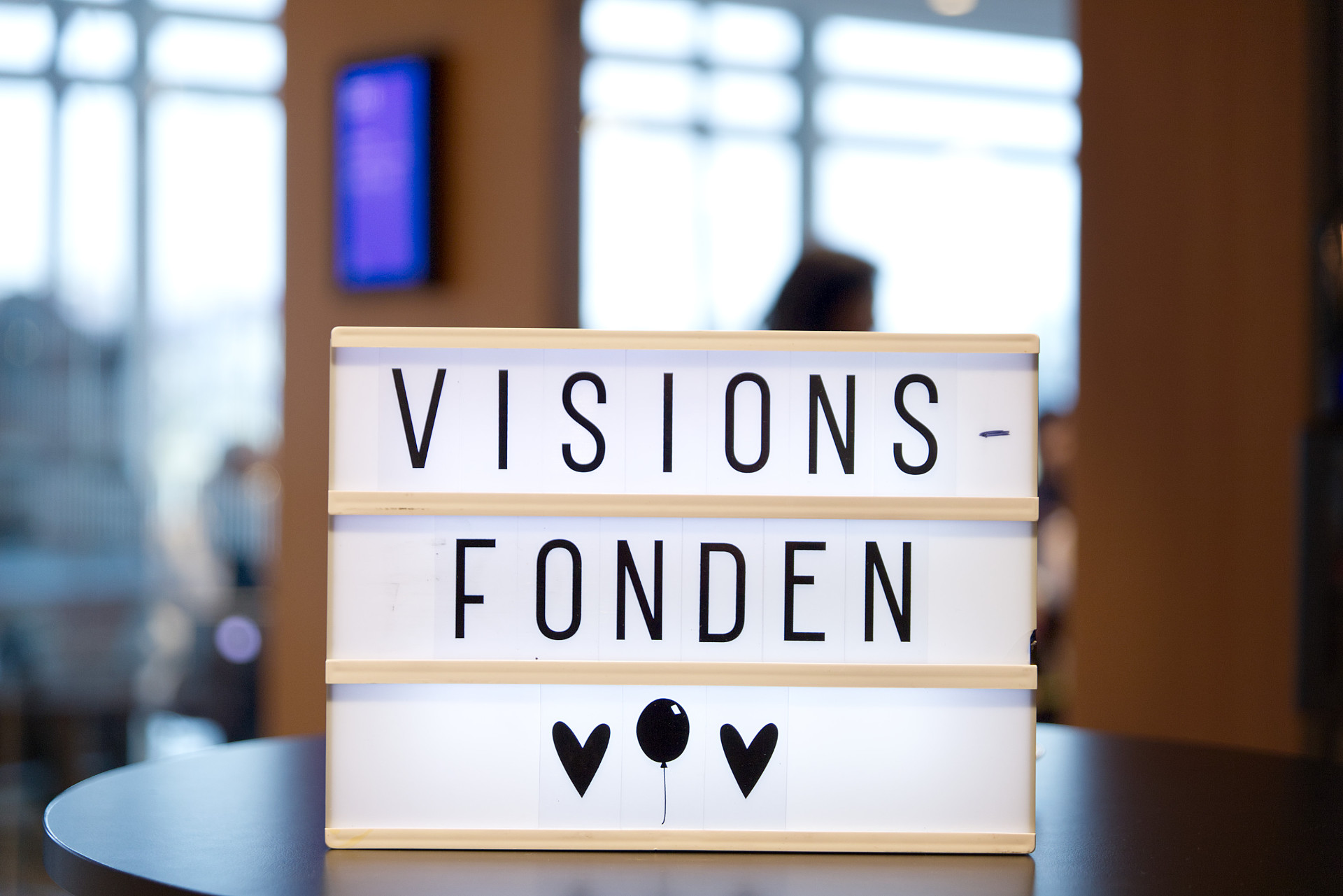 En ljusskylt på ett bord med bokstäver som formar ordet Visionsfonden
