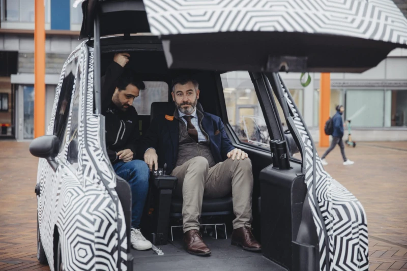 The 3D-printed vehicle can be loaded from both the front and back. Here, Christian Orsing (right), Mayor of the City of Helsingborg, test drives e-Miles.