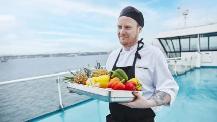 Sjökock Erik bär en låda med frukt och grönt