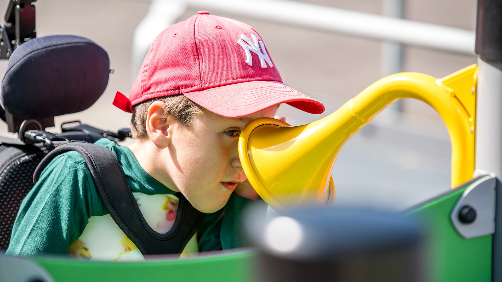 Pojke i rullstol vid lekredskap på Rymdlekan