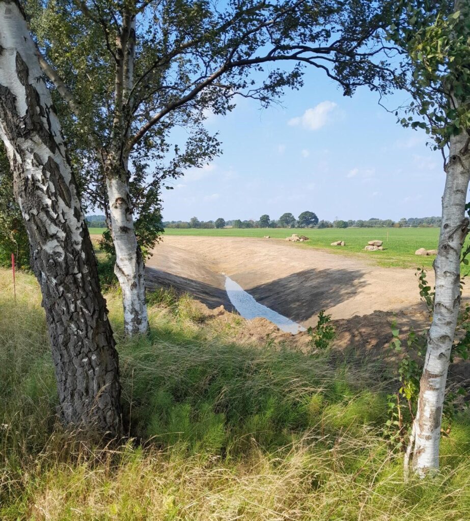 Ett framgrävt dike i kanten av en grön åkermark.