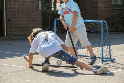 barn spelar landhockey utomhus