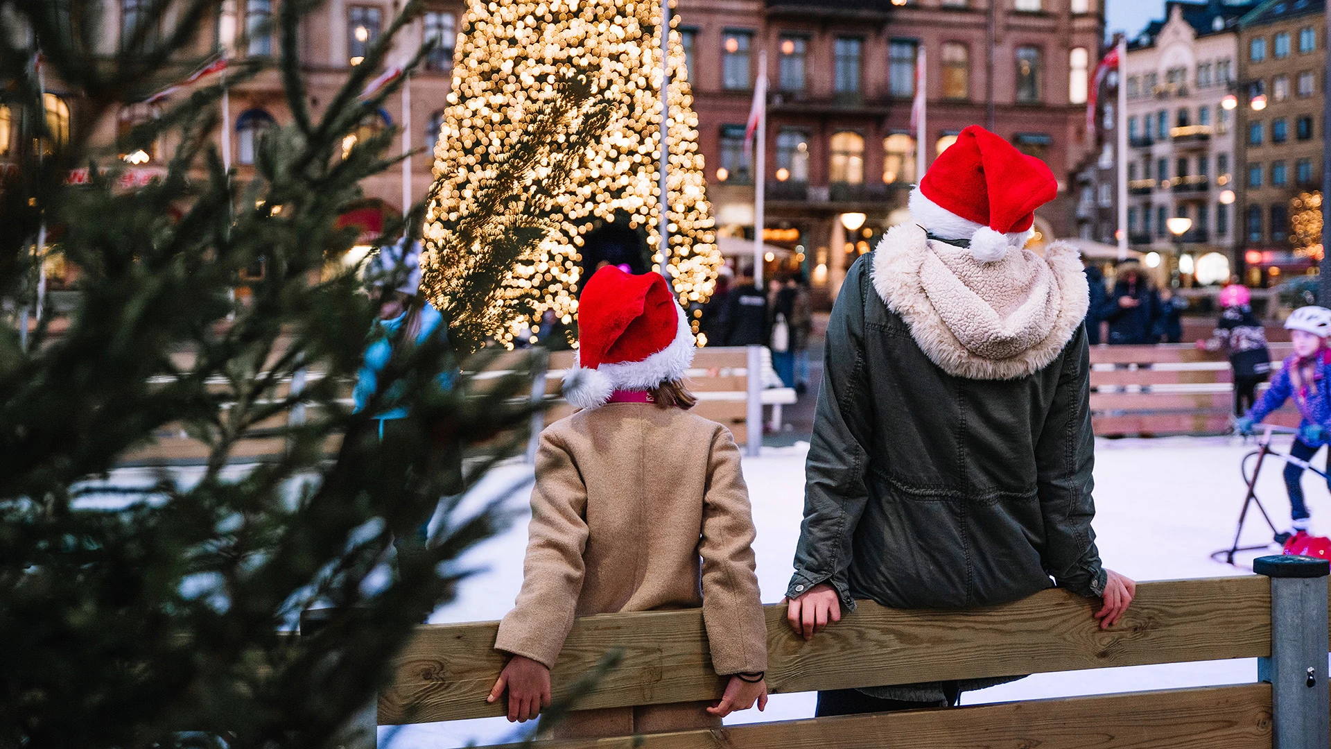 Två personer med tomteluvor på isbanan på Sundstorget.