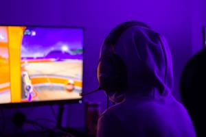 person med huvtröja spelar e-sport på fuzed sommarläger.