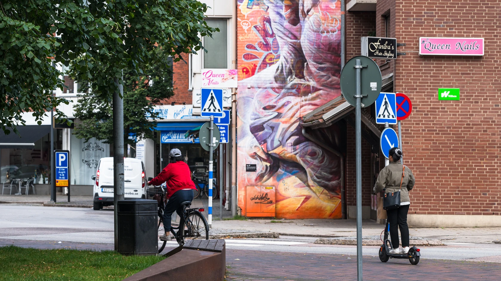Gatumiljö med cyklist och person på elsparkcykel på Söder i Helsingborg