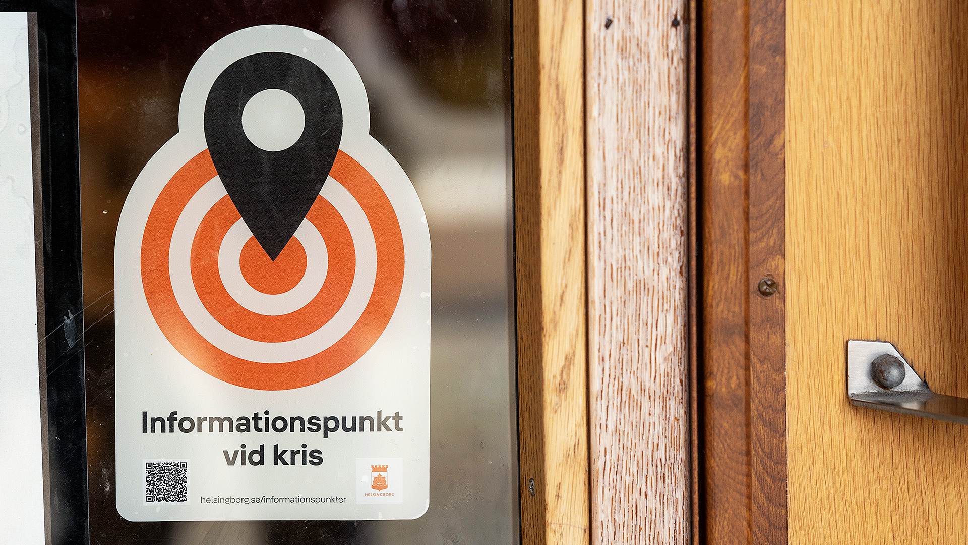 En dekal med texten "Informationspunkt vid kris" sitter på en ytterdörr