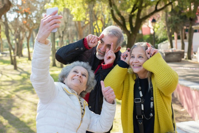 Tre seniorer tar en lustig selfie.