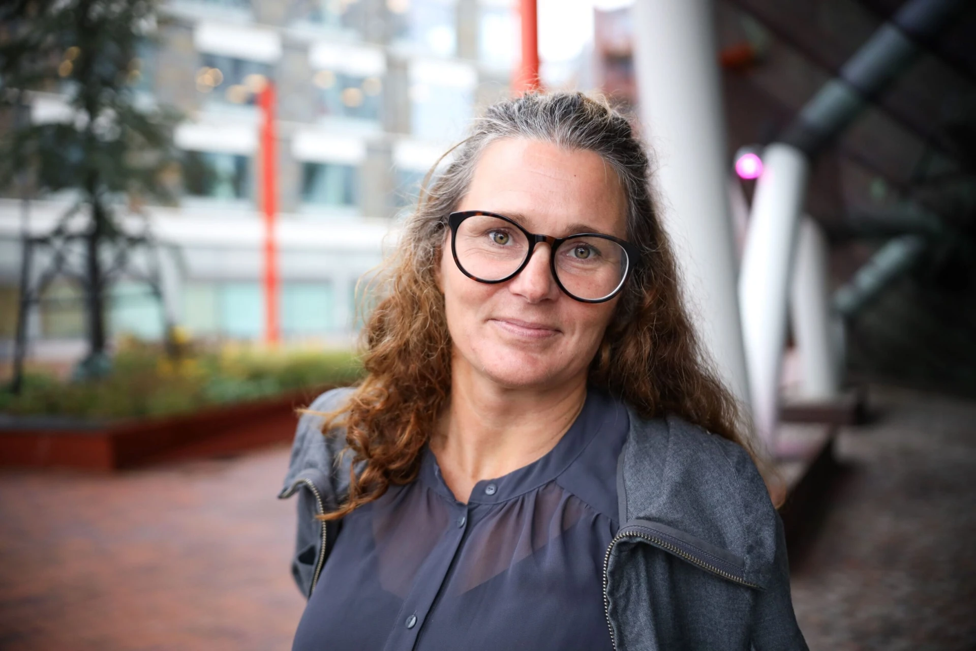 Leende kvinna med glasögon och brunt hår.