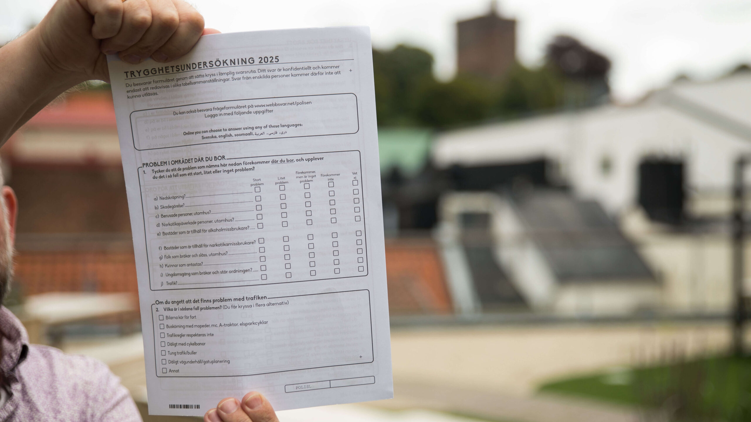 En person håller upp en pappersenkät.