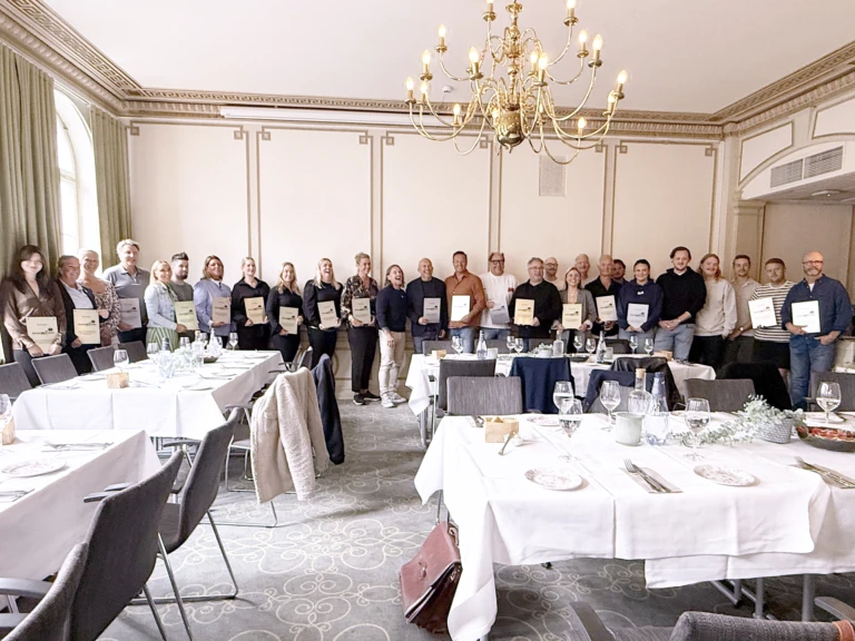 Personer står på rad i en lunchmatsal med plaketter i händerna