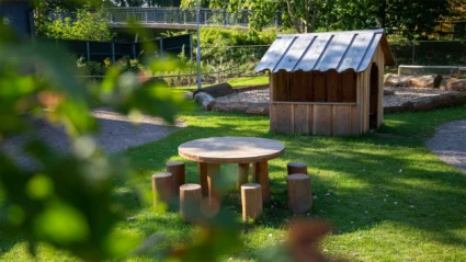 Dalhems förskola, del av gården med sittplatser och lekstuga i naturmaterial. Foto: ChHo SFF 2024