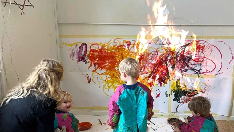 Foto med barn och pedagog som målar en eld