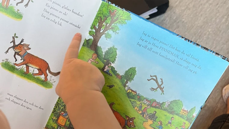Barn som pekar på text i en bok. Foto: Vintergatans förskola 2024
