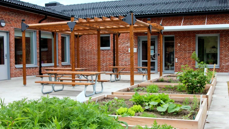 Trädgårdens förskola, vy från gården med odlingslådor i förgrunden. (Foto: SFF2022)