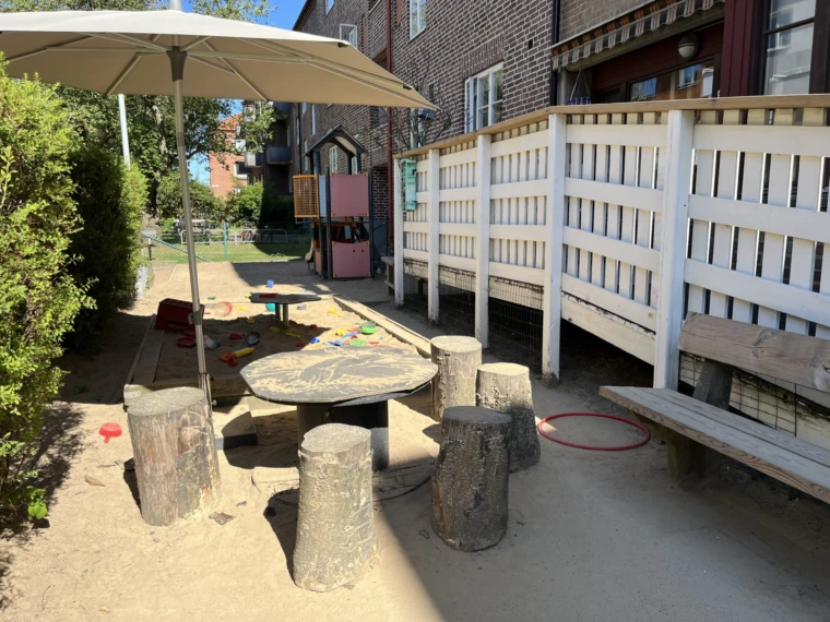 Guldsmedsgatans förskolas utemiljö har bland annat sandlåda, bord och pallar.
