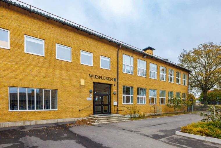 Bild på skolans fasad med en entré. Vy från skolgården.