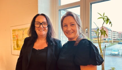 Två leende kvinnor.