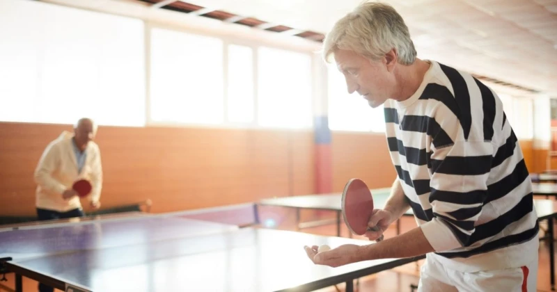 Två seniora män spelar pingis