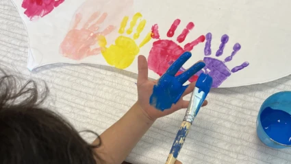 barn på Äppelgårdens förskola som målar med pensel på handen