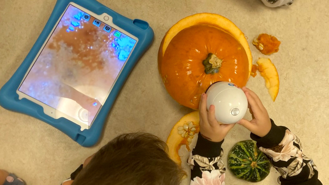 Foto på barn som filmar pumpa med digitalkamera på Äppelgårdens förskola