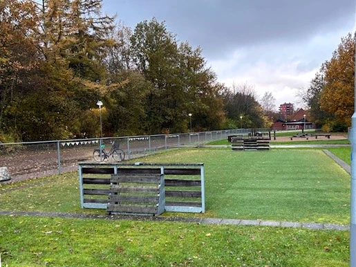 Foto på gården, en stor gräsmatta för bollspel och lek vid Galaxens förskola.