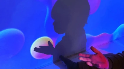 Foto med barn som siluett mot en vägg med digital teknik