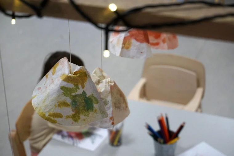 Foto på dekorationer av barnens egna alster som pryder taket tillsammans med en ljusslinga.